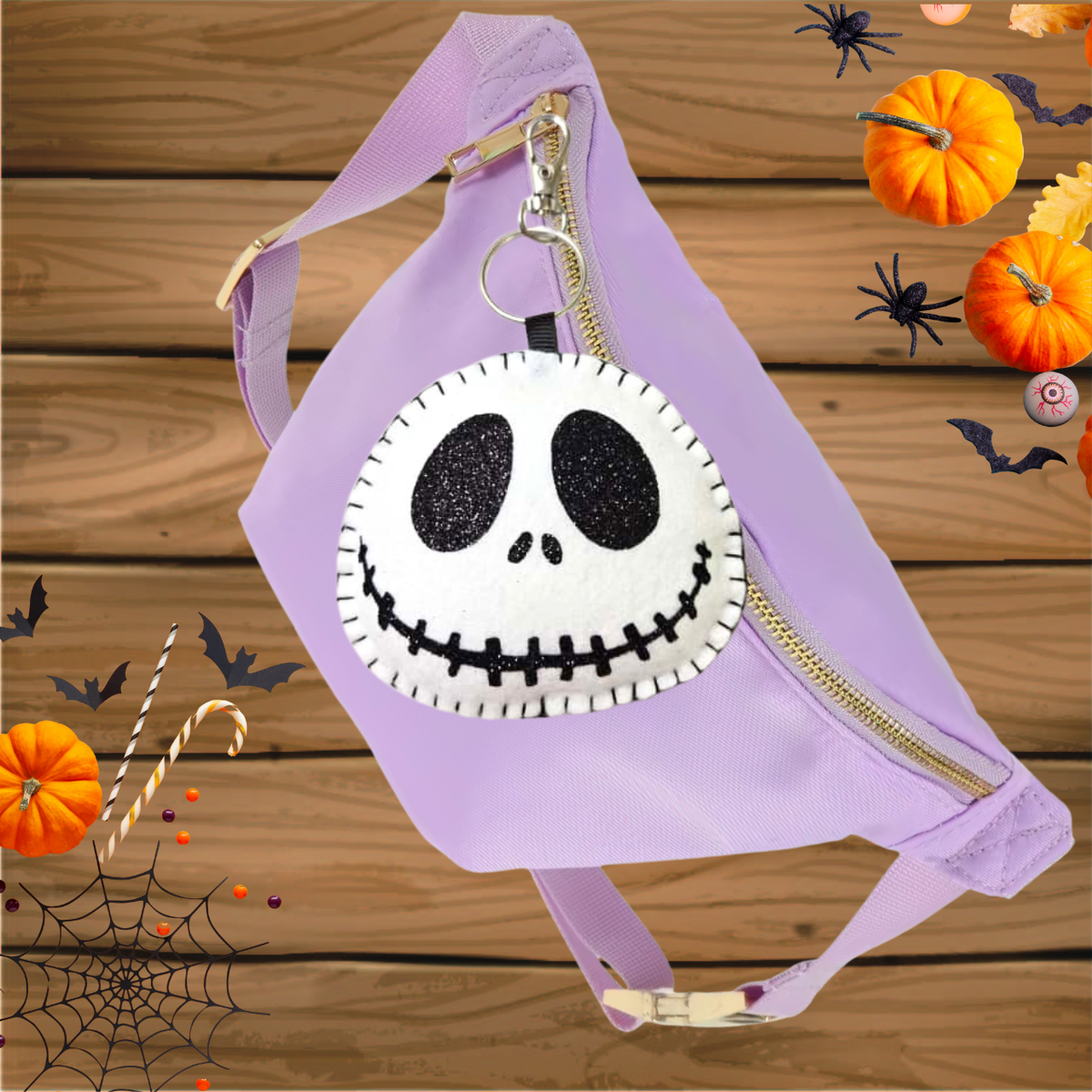 Felt Jack Skellington face patch on the front, gold zipper, and adjustable strap, displayed on a wooden background with Halloween decorations.